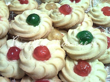 Primo piano biscotti di pasta frolla montata con ciliegina candita di Teresa Mastandrea