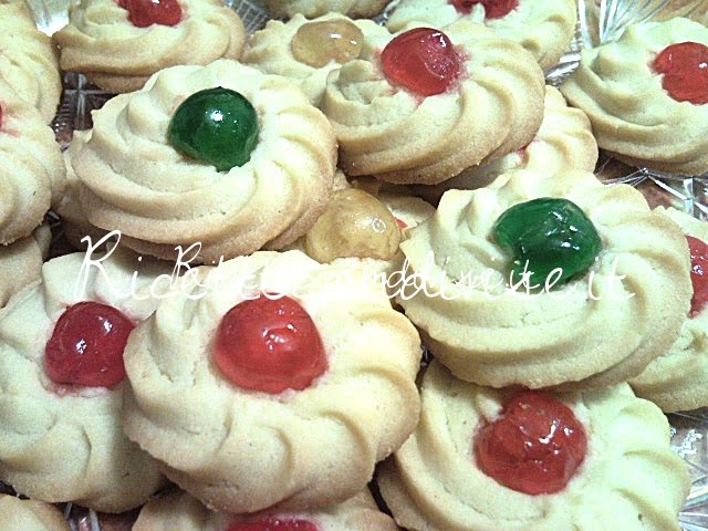 Primo piano biscotti di pasta frolla montata con ciliegina candita di Teresa Mastandrea