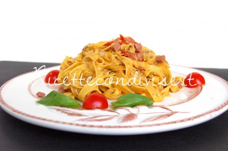 Primo piano Tagliatelle con mortadella, pomodorini e pesto basilico e rucola Primo piano Tagliatelle con mortadella pomodorini e pesto basilico e rucola